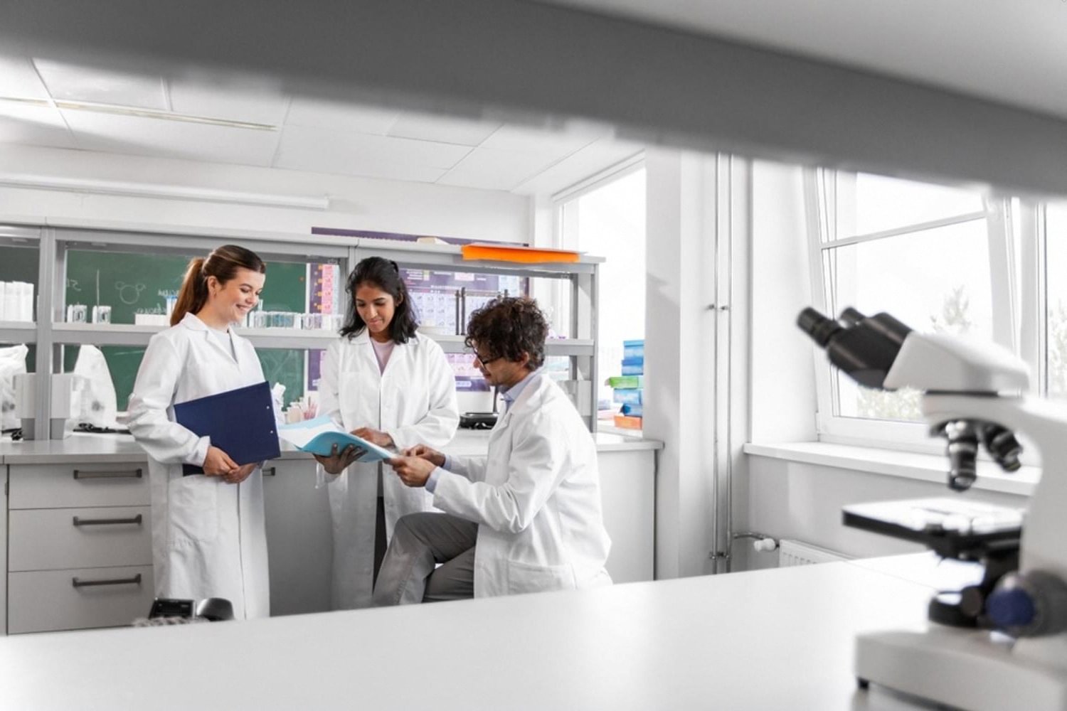 Students in white lab coats reviewing course materials during a career training session